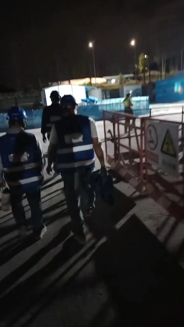 Workers in hi-vis regular workwear vests at night